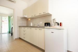 a kitchen with white cabinets and a sink at Apartments with parking space Orebic, Peljesac - 10173 in Orebić +15 photos