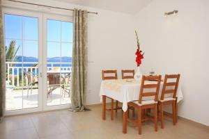 a dining room with a table and chairs and a balcony at Apartments with parking space Orebic, Peljesac - 10173 in Orebić