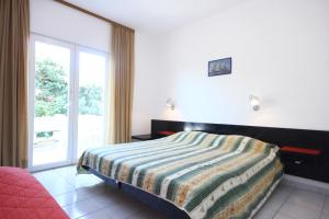 una camera con un letto e una grande finestra di Apartments by the sea Viganj, Peljesac - 10187 a Viganj