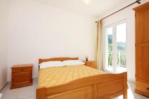 1 dormitorio con cama y ventana en Apartments with a parking space Viganj, Peljesac - 10188 en Viganj