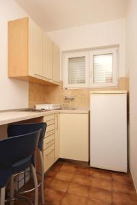 cocina con armarios blancos y nevera blanca en Apartments with a parking space Viganj, Peljesac - 10188 en Viganj