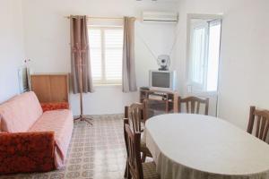 ein Wohnzimmer mit einem Tisch und einem TV in der Unterkunft Seaside holiday house Susica, Ugljan - 9664 in Ugljan