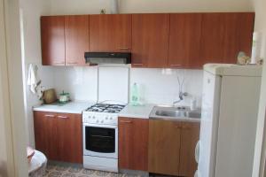 a kitchen with wooden cabinets and a stove and a sink at Seaside holiday house Susica, Ugljan - 9664 in Ugljan