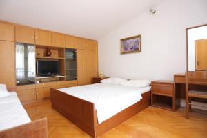 a bedroom with two beds and a flat screen tv at Apartments with a parking space Makarska - 9506 in Makarska