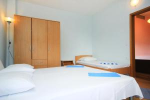 1 dormitorio con 2 camas blancas y armario en Apartment Orebic 10256b en Orebić