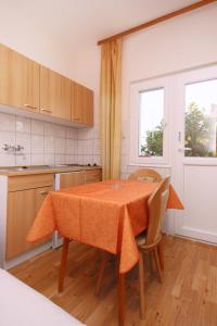a kitchen with a table with chairs and a window at Apartment Orebic 10256b in Orebić