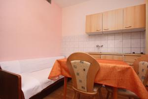 cocina con mesa, sillas, mesa y armarios en Apartment Orebic 10256b en Orebić