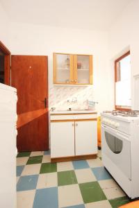 a kitchen with white cabinets and a checkered floor at Apartments with a parking space Orebic, Peljesac - 10256 in Orebić