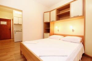 een slaapkamer met een groot wit bed en een keuken bij Studio Orebic 10256b in Orebić
