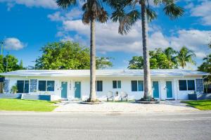 ein weißes Haus mit Palmen davor in der Unterkunft Cozy 1 BDR Unit by Beach, Mall, & Downtown FTL in Fort Lauderdale