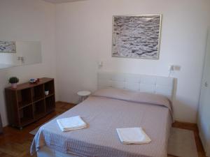 1 dormitorio con 1 cama con 2 toallas en Apartment Orebic 10153f, en Orebić