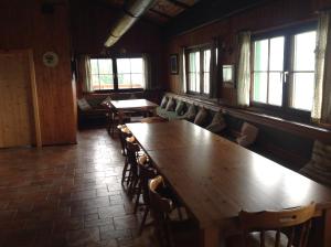a dining room with tables and chairs and windows at The Pirklalm in Pruggern