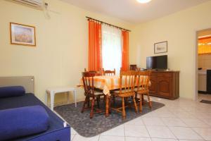 a living room with a table and a blue couch at Apartment Mastrinka 10261b in Trogir