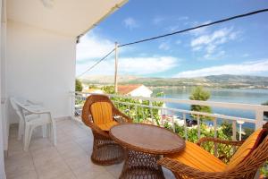a balcony with a table and chairs and a view of the water at Apartment Mastrinka 10261b in Trogir
