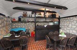 a restaurant with tables and chairs and a stone wall at Apartments with a parking space Njivice, Krk - 9668 in Njivice