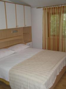 ein Schlafzimmer mit einem großen Bett und einem Fenster in der Unterkunft Apartments with a parking space Orebic, Peljesac - 10096 in Orebić
