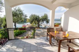 a patio with a table and chairs and a view of the water at Apartment Zuronja 10134b in Brijesta