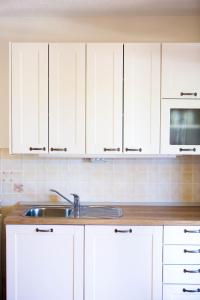 uma cozinha com armários brancos e um lavatório em Family friendly house with a swimming pool Zavalatica, Korcula - 9476 em Zavalatica