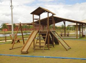 un parco giochi in legno con scivolo e tetto di Villa das aguas -Praia do saco -Próximo as lagoas dos Tambaquis e Mangue Seco -térreo a Estância