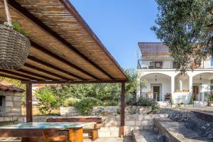 una pérgola de madera con una mesa en un patio en Apartments by the sea Zuronja, Peljesac - 10134 en Brijesta