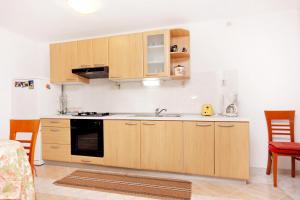 a kitchen with wooden cabinets and a sink at Apartments by the sea Basina, Hvar - 9673 in Vrbanj