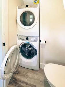 a washing machine sitting next to a toilet in a bathroom at Unique Upper Suite Near Lakes, River, Hiking, Fishing, Bike Trails in Chilliwack