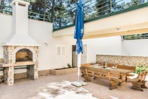 eine Terrasse mit einem Holztisch und einem Kamin in der Unterkunft Apartments by the sea Rogac, Solta - 11655 in Grohote