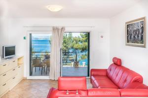 a living room with a red couch and a sliding glass door at Apartments by the sea Rogac, Solta - 11655 in Grohote