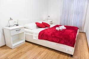 a bedroom with a white bed with a red blanket at Apartments by the sea Rogac, Solta - 11655 in Grohote
