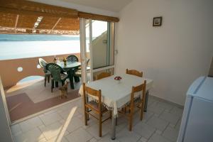 una sala da pranzo con tavolo, sedie e un cane di Apartments by the sea Zubovici, Pag - 9678 a Zubovići
