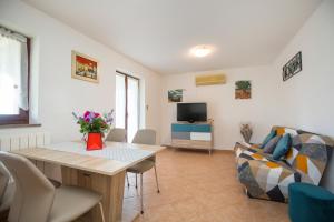 uma sala de estar com uma mesa e um sofá em Apartments for families with children Presika, Labin - 11656 em Labin
