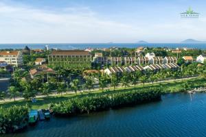 an aerial view of a resort with palm trees and water at Silk Sense Hoi An River Resort - A Sustainable Destination in Hoi An