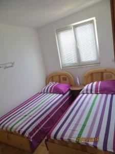 2 łóżka pojedyncze w pokoju z 2 oknami w obiekcie Apartments with a parking space Rogoznica - 11679 w Rogoznicy
