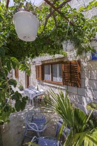 un patio con sillas, una mesa y una ventana en Apartments by the sea Komiza, Vis - 11671, en Komiža 12 fotos más