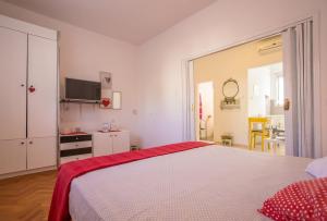 a white bedroom with a bed and a tv at Apartments by the sea Komiza, Vis - 11671 in Komiža