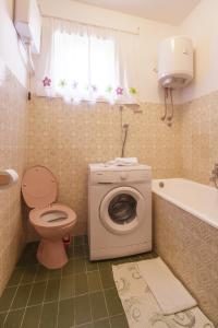 uma casa de banho com um WC e uma máquina de lavar roupa em Apartments by the sea Komiza, Vis - 11671 em Komiža