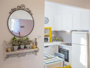 uma cozinha com armários brancos e um espelho em Apartments by the sea Komiza, Vis - 11671 em Komiža