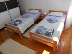 two twin beds in a room with wooden floors at Apartments with WiFi Split - 11692 in Split