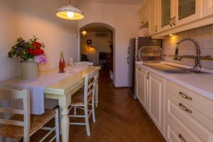 a kitchen with a table with chairs and a sink at Apartments by the sea Selce, Crikvenica - 11693 in Selce