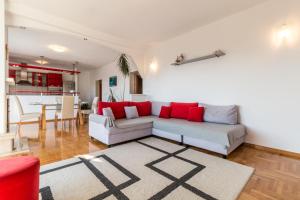 ein Wohnzimmer mit einem weißen Sofa und roten Kissen in der Unterkunft Apartments with a parking space Kastel Kambelovac, Kastela - 11678 in Kaštela