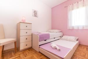 ein kleines Schlafzimmer mit einem Etagenbett und einem Stuhl in der Unterkunft Apartments with a parking space Kastel Kambelovac, Kastela - 11678 in Kaštela