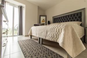 Dormitorio con cama con cabecero negro y alfombra en NIZA FIVE Luxury Beach Apartments, en Puerto Vallarta