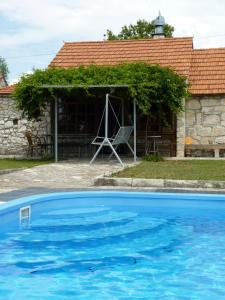 a blue swimming pool in front of a house at Holiday house with a swimming pool Gornje Planjane, Zagora - 11701 in Sedramić