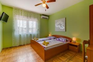1 dormitorio con 1 cama y ventilador de techo en Rooms with a parking space Mali Losinj (Losinj) - 9681, en Mali Lošinj