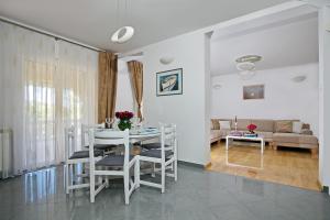 a dining room and living room with a table and chairs at Holiday house with a swimming pool Lozovac, Krka - 11715 in Lozovac