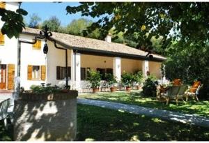 una gran casa blanca con un patio con sillas en Albergo Volpara, en Mussolente 