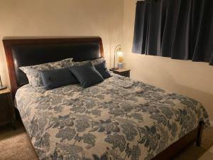 1 dormitorio con 1 cama grande con manta y almohadas en Lake Murray House, en La Mesa