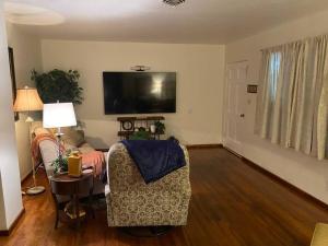 sala de estar con sofá y TV en Lake Murray House, en La Mesa