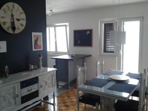 a dining room with a table and a clock on the wall at Apartments by the sea Vranjic, Split - 11753 in Vranjic