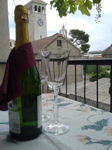 a bottle of wine and a wine glass on a table at Apartments by the sea Vranjic, Split - 11753 in Vranjic